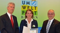 Ministerialdirigent Dr. Witzmann überreicht Cornelia Schambeck und Bernhard Greinsberger die Urkunde. 