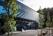 Der markante blaue Kubus mit 2.200 Quadratmeter großer Textilfassade steht für den ressourcenschonenden Umbau einer ehemaligen Produktionshalle und wurde von der Architektenkammer Baden-Württemberg als „Beispielhaftes Bauen“ ausgezeichnet.