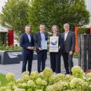 Matthias Hausmann von der IHK Schwaben (links) übergibt im Beisein des stellvertretenden Landrats Martin Stegmair (rechts) die EMAS-Urkunde an Roland Handschiegel und Stine Blinne von Hama.